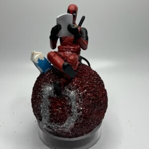 Deadpool w milk sitting on 4” red Sphere.